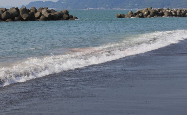 赤い汚水が海へ混じった写真